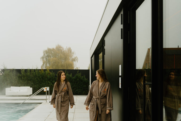 Gasten in badjas bij het buitenzwembad van Sané Thermen